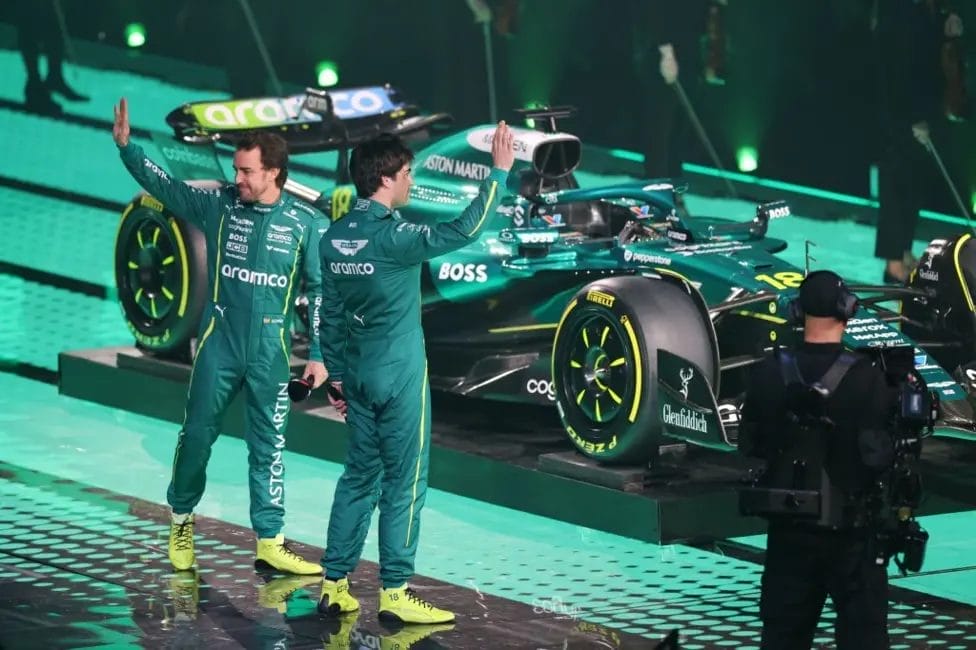 Aston Martin drivers Fernando Alonso (left) and Lance Stroll wave to the crowd

